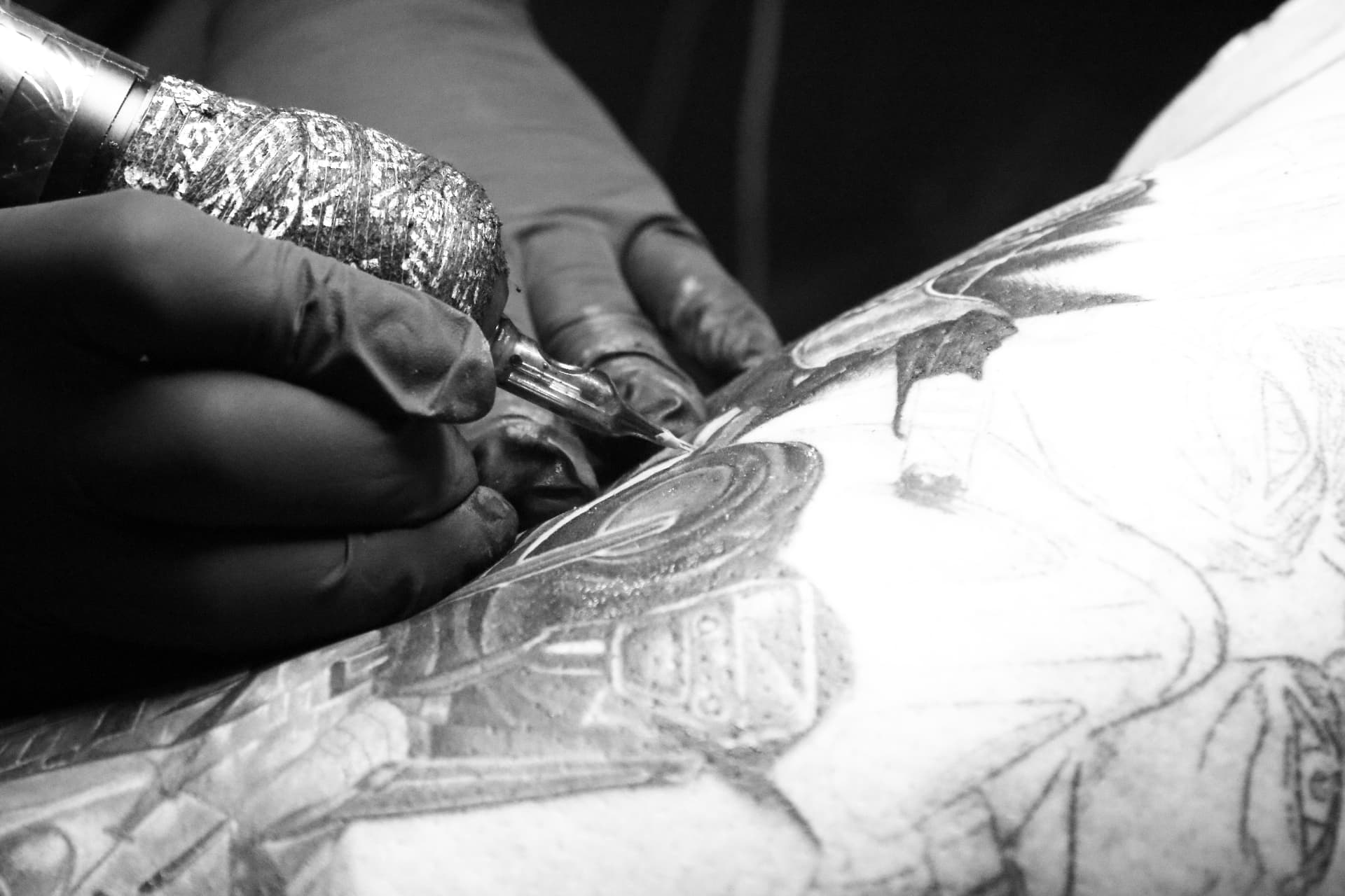 Tattoo artist working on a large back piece
