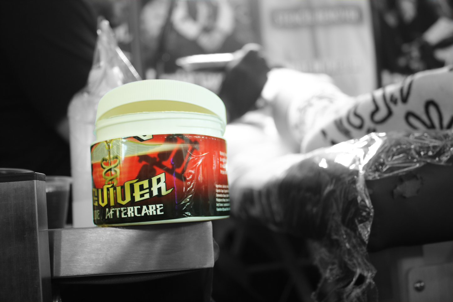 8oz jar of Tattoo Reviver Glide and Aftercare in use by a tattoo artist